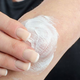 Sara Holloway applies lotion on her arm.